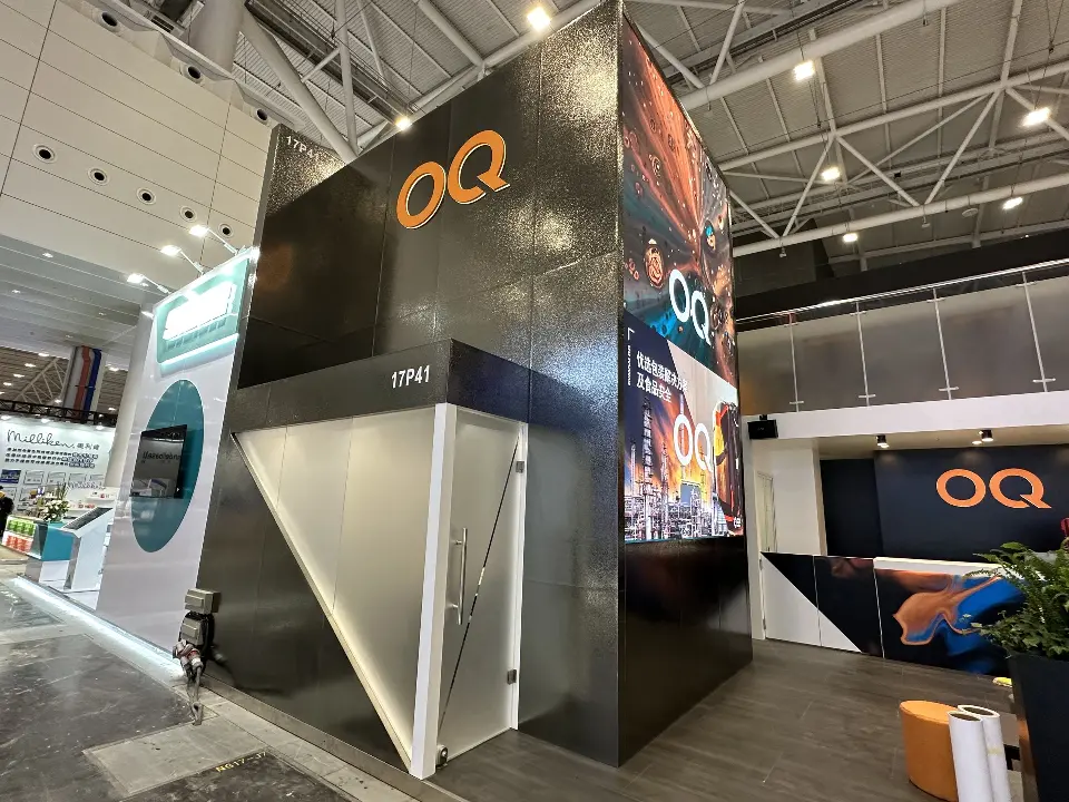 Black OQ tower corner with angled white panel and orange cushion seating