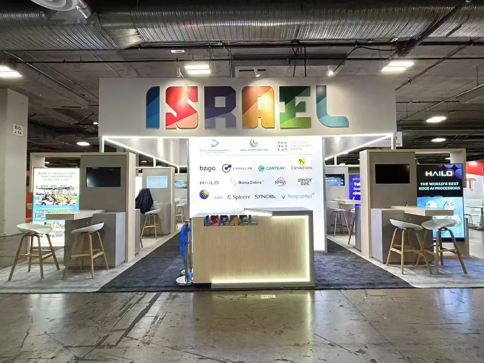 Israel Pavilion front with colorful ISRAEL header, lit counter and high tables