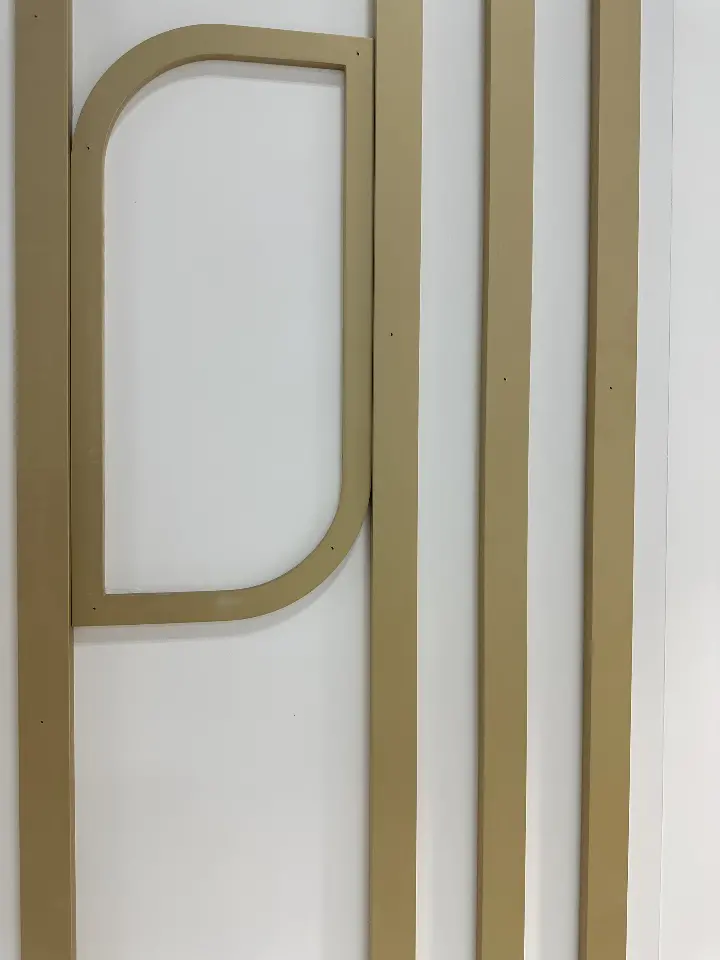 Portrait close-up of rounded gold line detailing on white panels