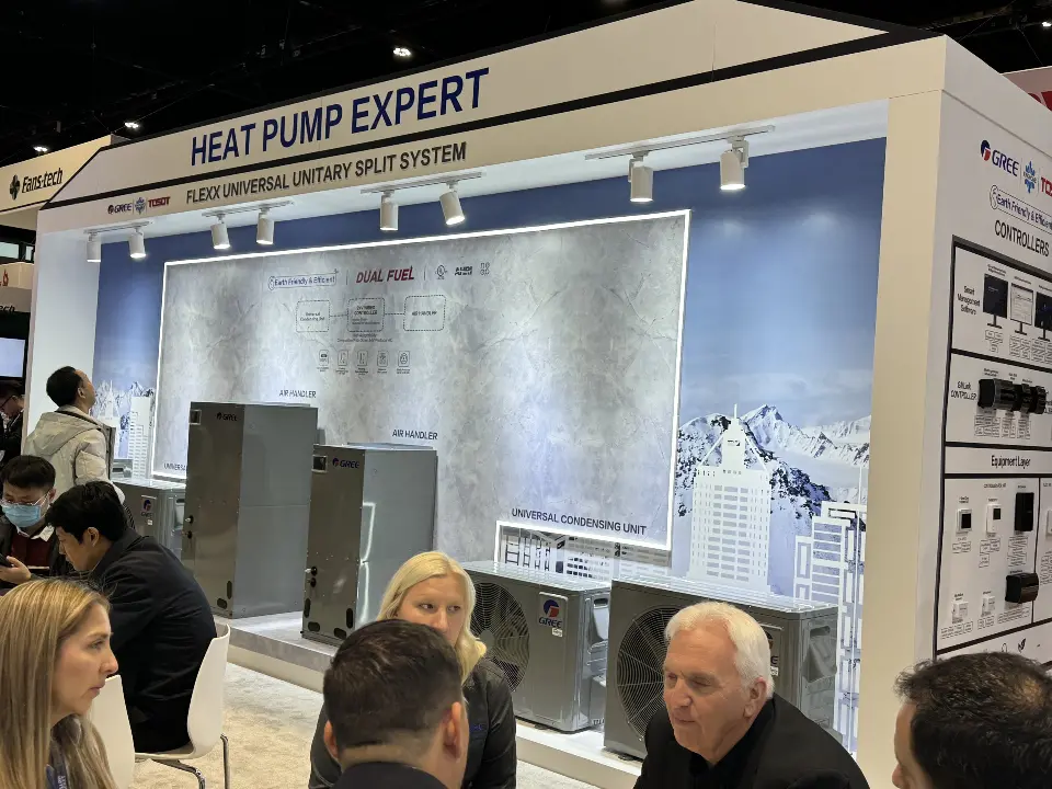 Heat Pump Expert header over an indoor unit display with seated guests