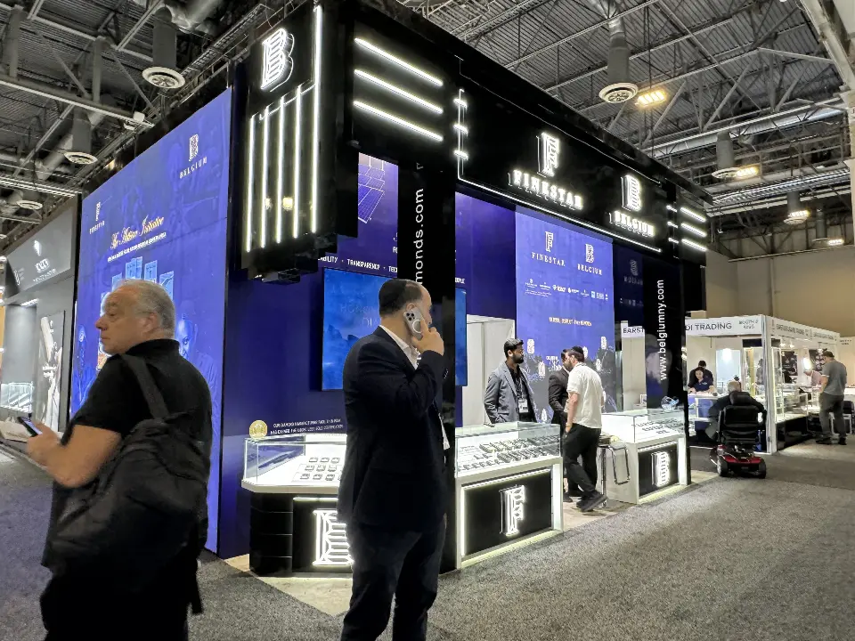 Visitors at Finestar Belgium jewelry showcases with monogram bases and light bars