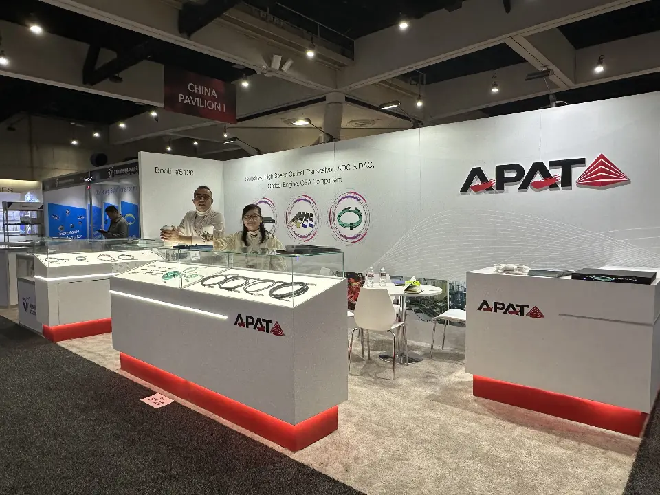APAT white showcases with red glowing bases and product samples before the logo wall