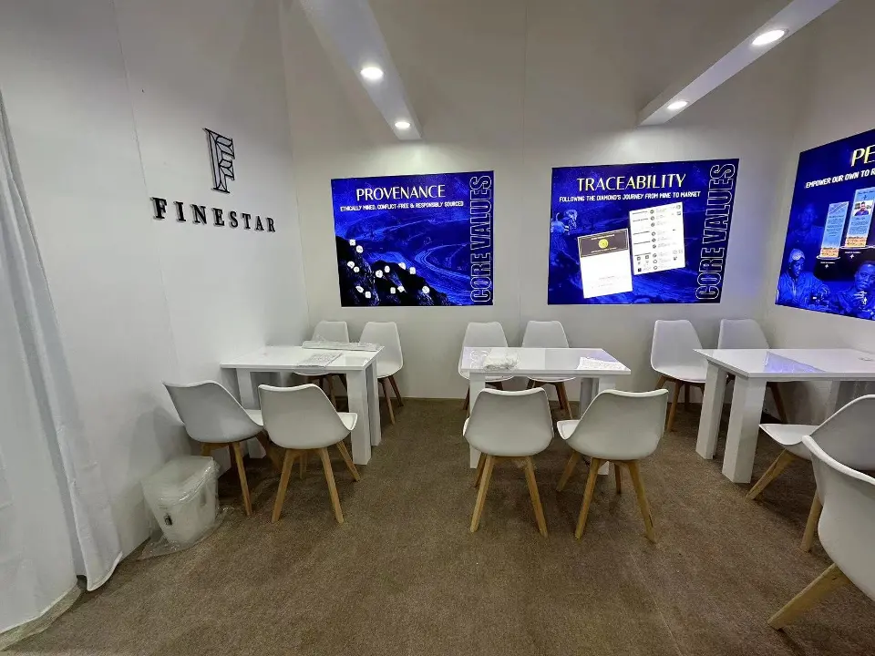 Wide meeting room view with rows of white chairs and backlit panels