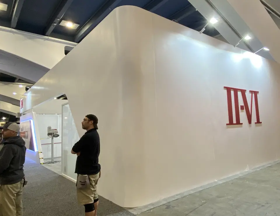 Curved white outer wall with large red II-VI letters and a visitor
