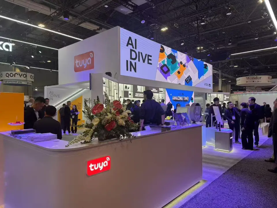 Corner of the Tuya booth with a white counter and colorful product graphic wall