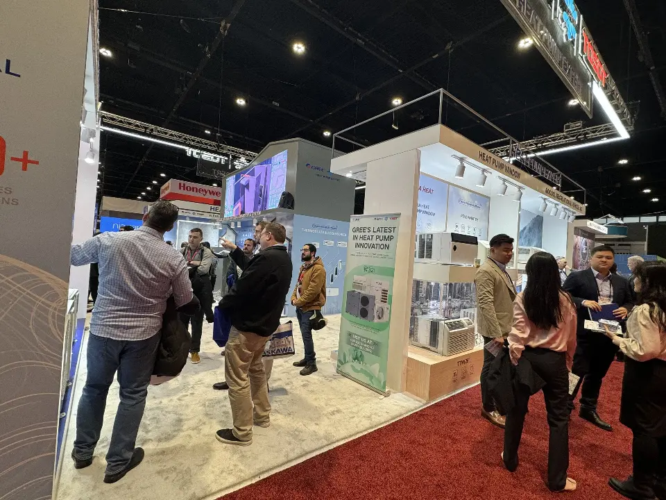 Visitors gathering at a GREE product corner with tall graphic panels