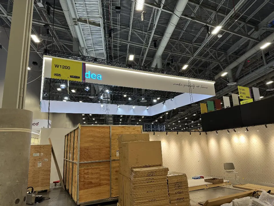 During installation: stacked wooden crates beside the lit header of the frame