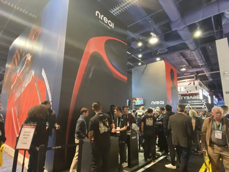 Crowd gathered at the booth under the red glasses and silhouette graphics