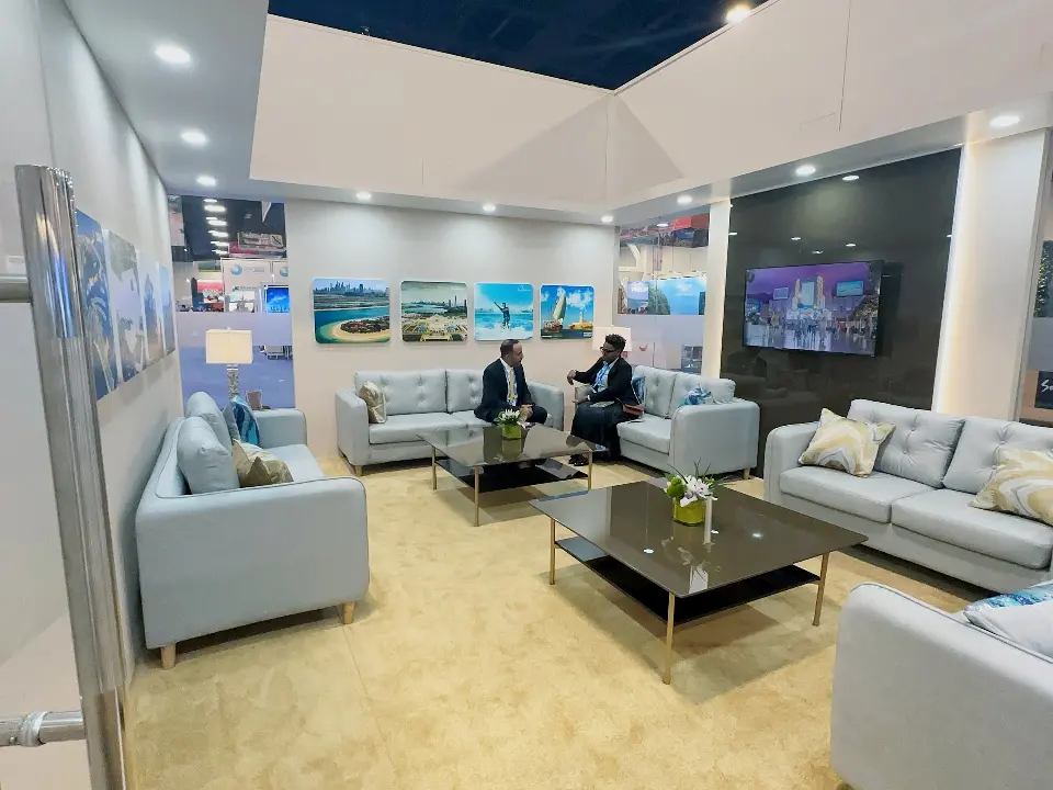 Lounge with white sofas, coffee table and video screen in the booth interior