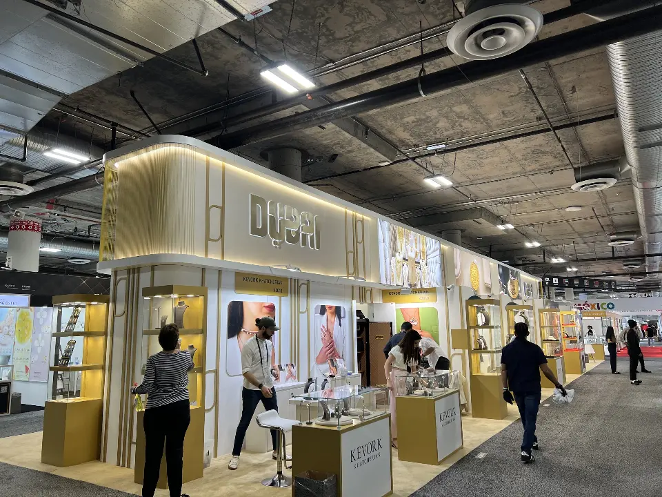 Long view of the pavilion with Kevork Khatcherian unit, gold display towers and backlit jewelry graphics