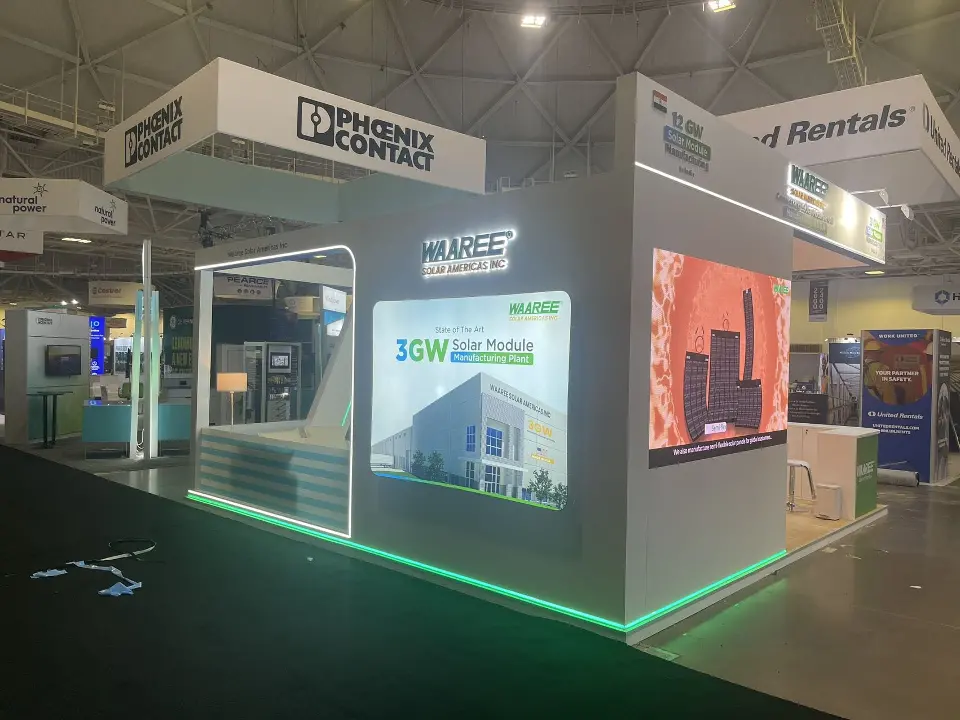 White booth corner with backlit solar graphic and green light strip at the base