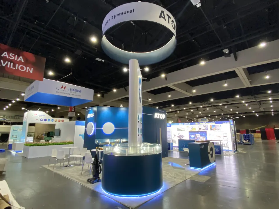 Tall white spire rising from a round navy showcase in the booth centre