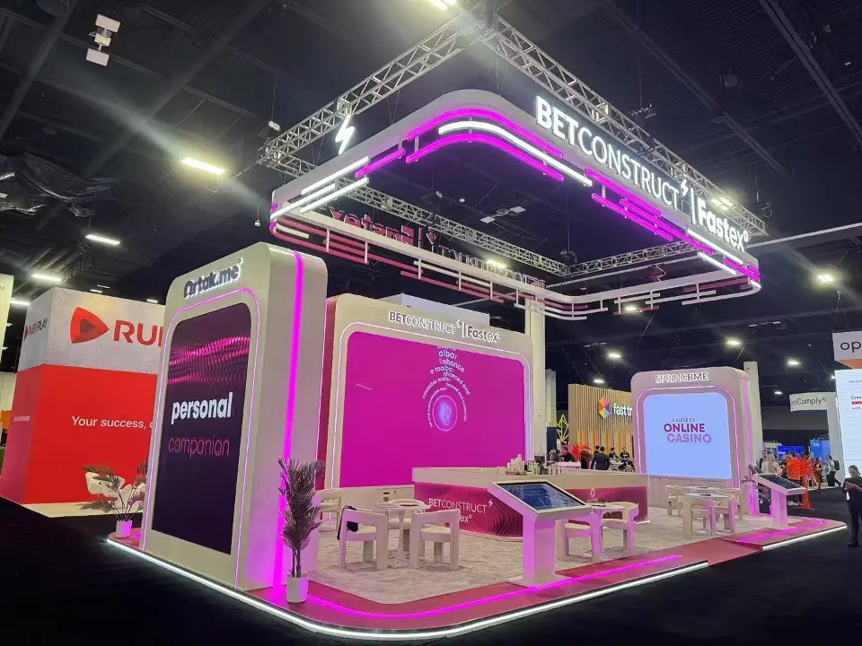 Side view with pink graphic towers and lit truss canopy overhead
