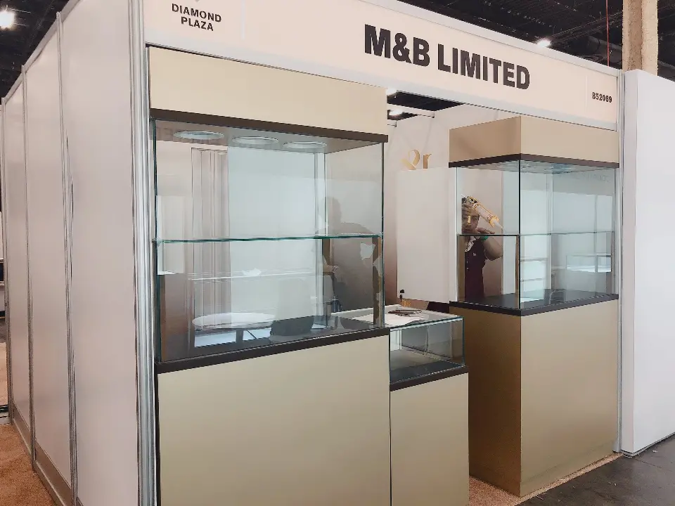 During build-up: M&B LIMITED header above beige cabinet showcases with glass tops