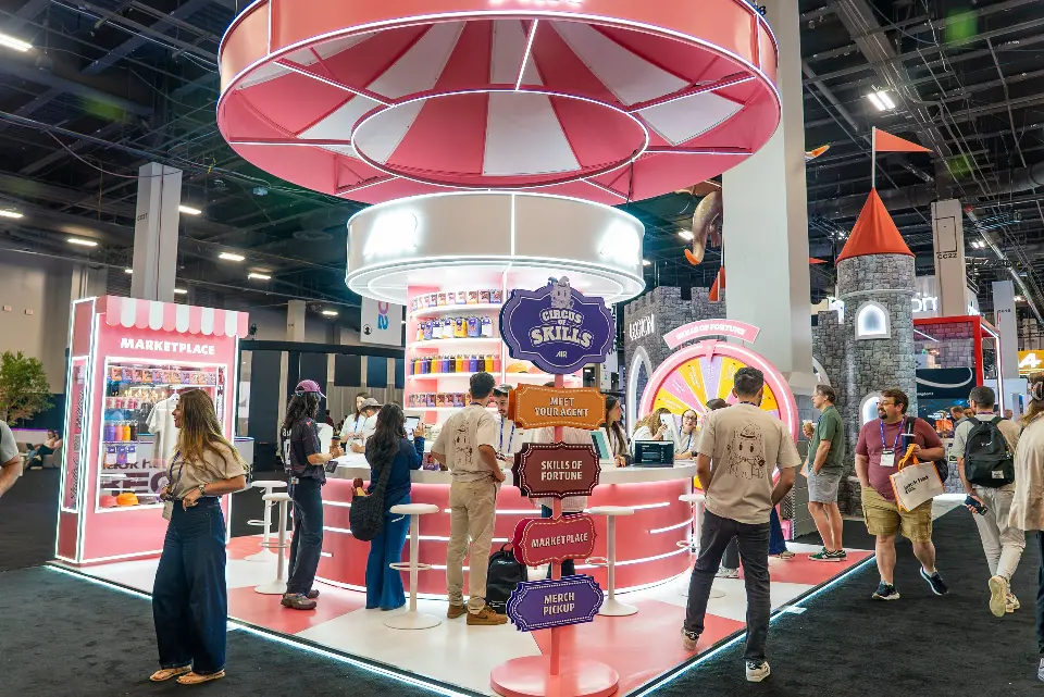 Visitors at the AIR booth during the show, with skills signposts and a castle tower beside the counter