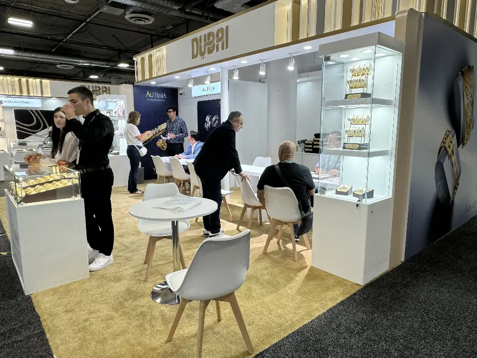 Visitors seated at a white table inside a stand with tall showcases