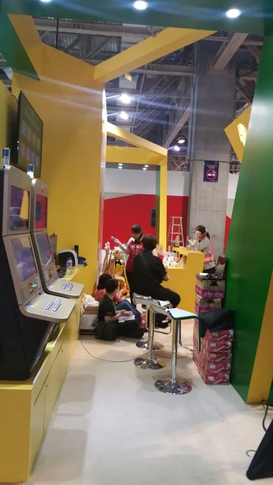 Narrow view of a green angled panel and seating area at the booth edge