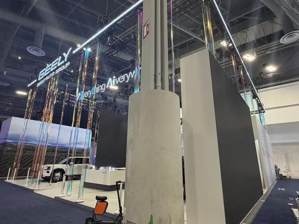 White SUV beside a tall column with hanging strands overhead