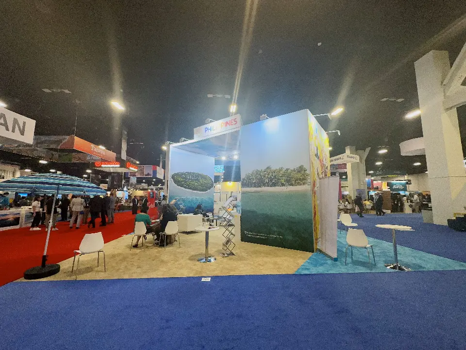 Side of the Philippines space with island photo walls, a striped beach umbrella and white chairs