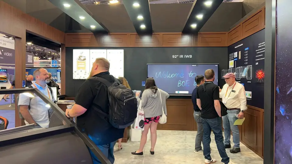 Visitors inside a wood-look room watching a large wall screen