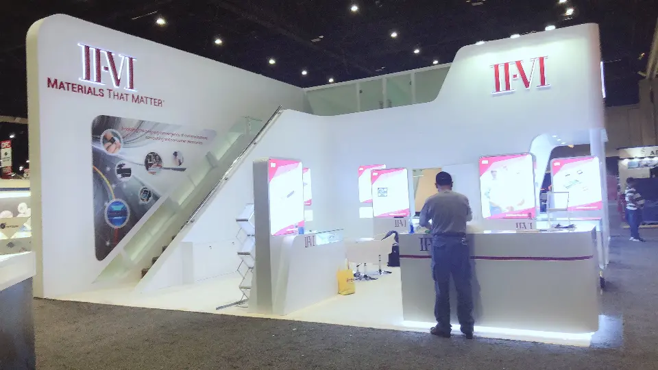Staff member at the white counter with backlit product graphics behind