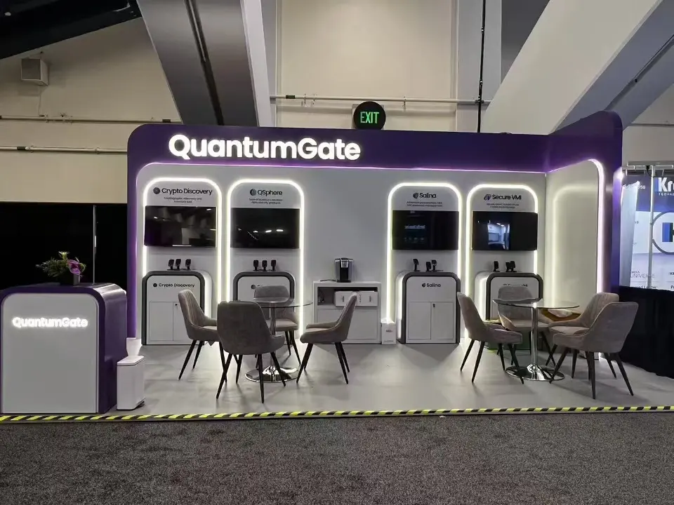 Straight-on view of the QuantumGate stand with backlit product alcoves, wall screens and lounge chairs