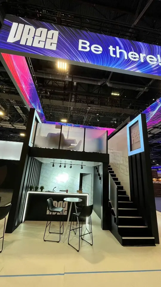 Booth side with Be there header, black staircase and bar seating beneath