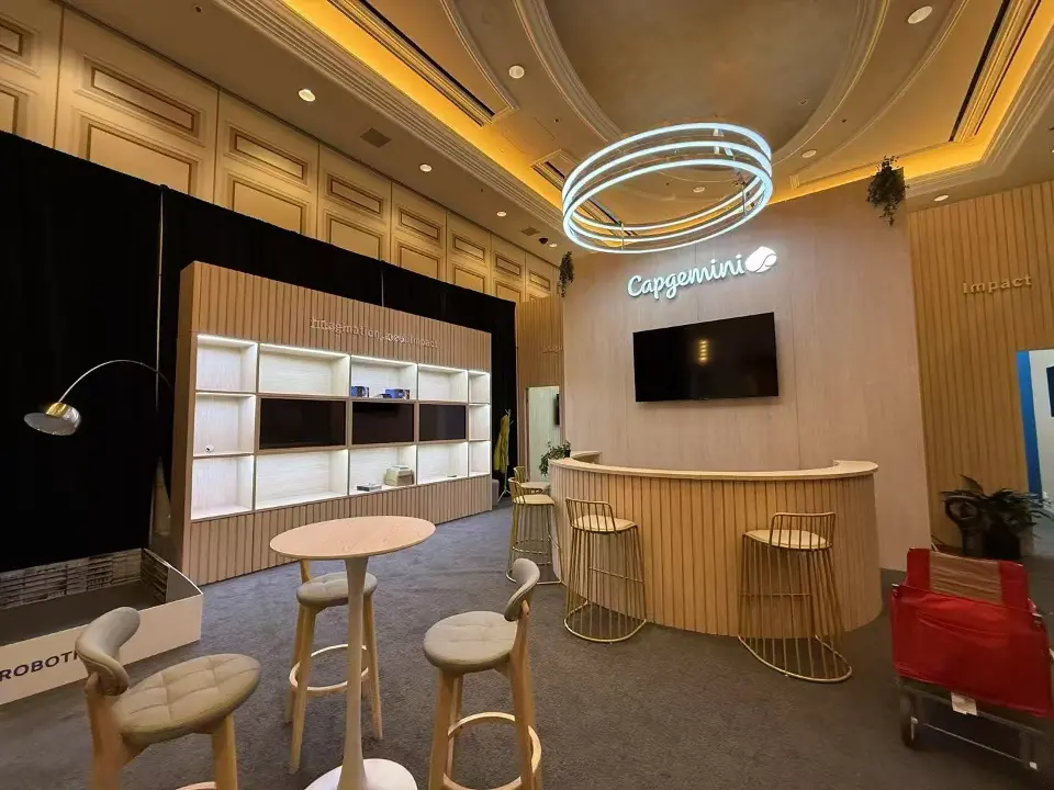 Capgemini meeting suite with wood-look counter, bar tables and glowing ring light