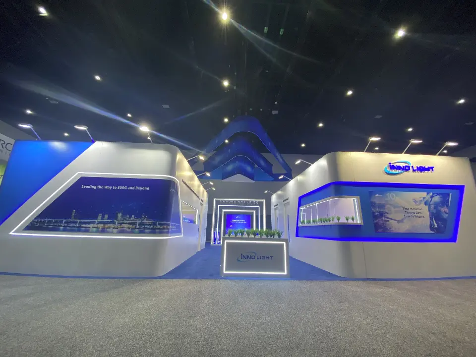 Symmetrical front of the InnoLight booth with curved white wings and glass showcases