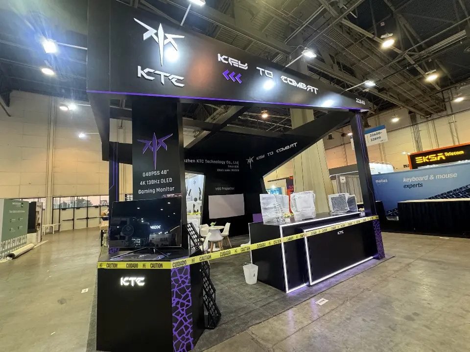 During build-up: front of the KTC booth with logo header, monitors and central column