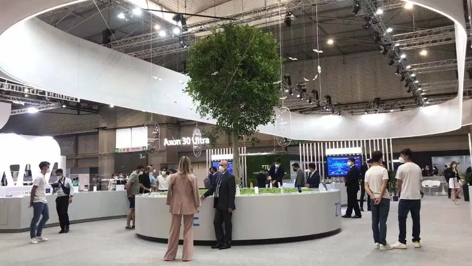 Visitors standing around the tree counter beneath the curved white rings