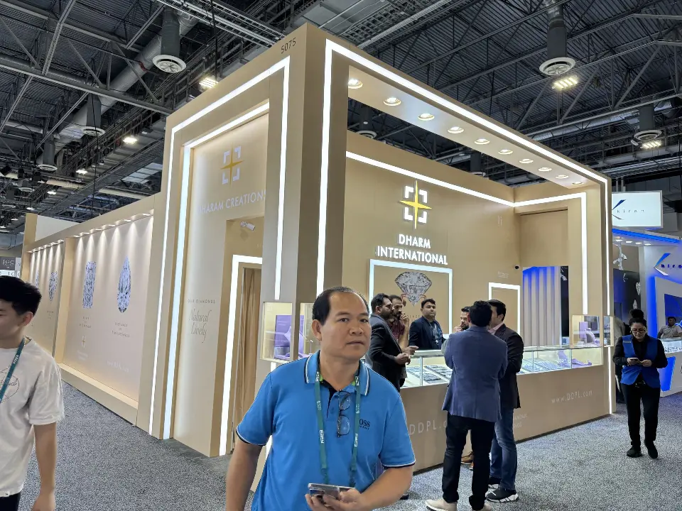 Corner angle with visitors along the showcases and the backlit Dharm logo