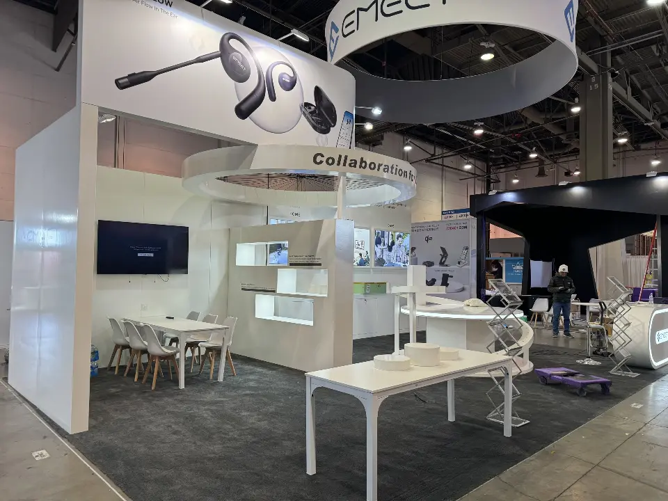 White tables and chairs with a wall screen and shelving under the product graphic