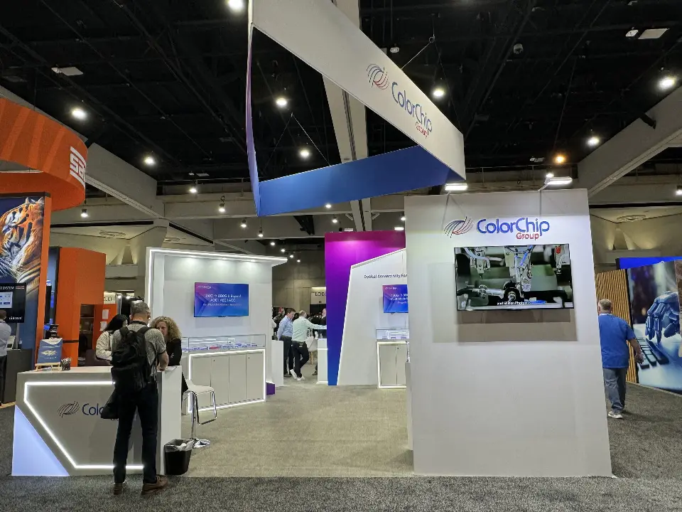 Booth corner with wall screen, purple panel and angled hanging sign above