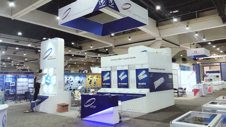 During build-up: wide view of the hanging sign, product graphic wall and blue-lit counters