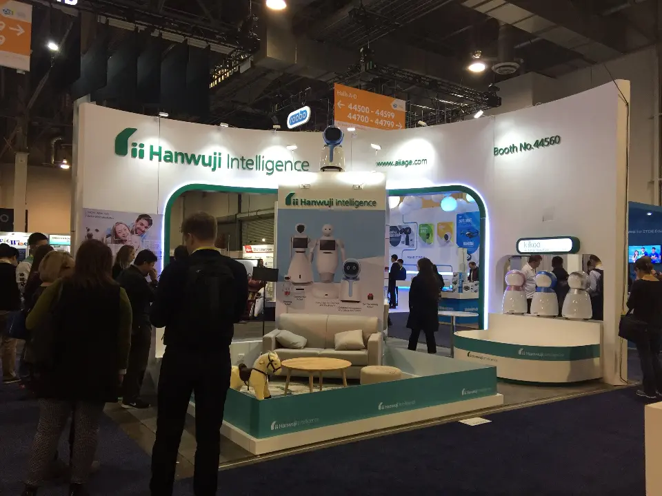 Packed aisle view of the kids lounge and robot shelves at the Hanwuji booth