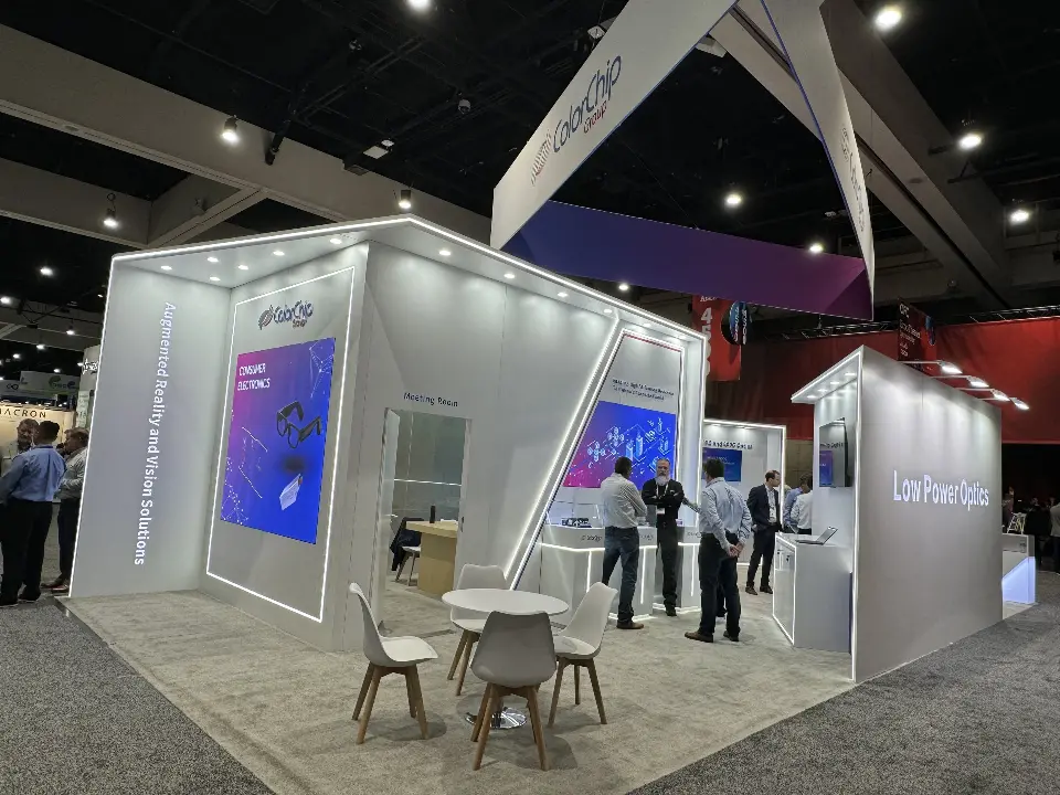 Open side of the white booth with meeting chairs, gradient panels and screens