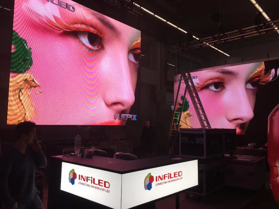 Wide view of two angled video screens above a white INFiLED counter