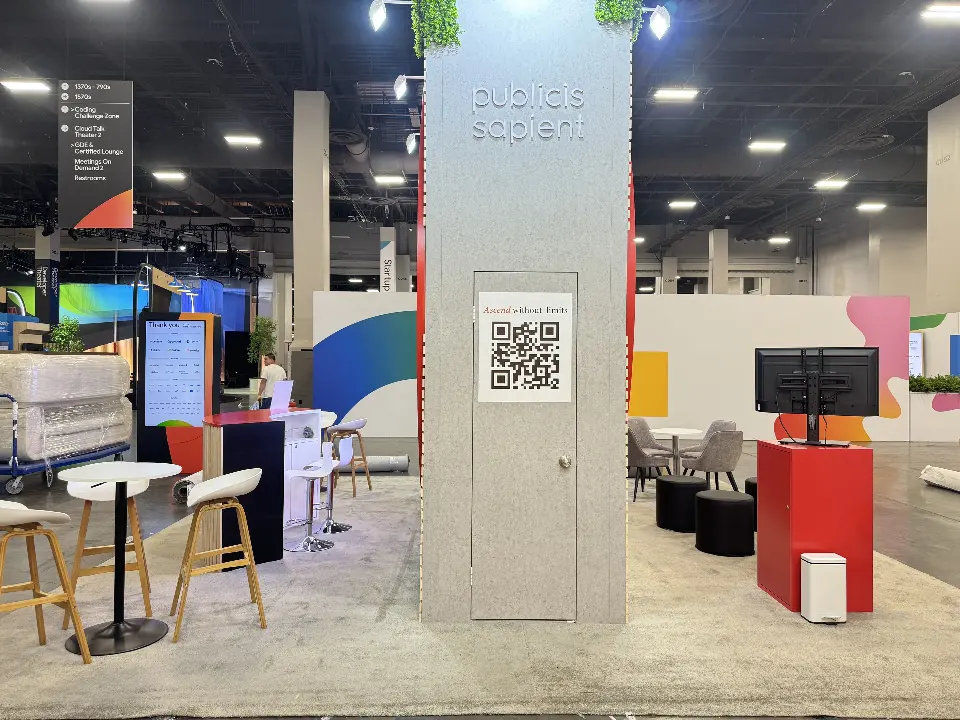 Publicis Sapient branded column with QR code panel, high-top tables and stools at the booth edge