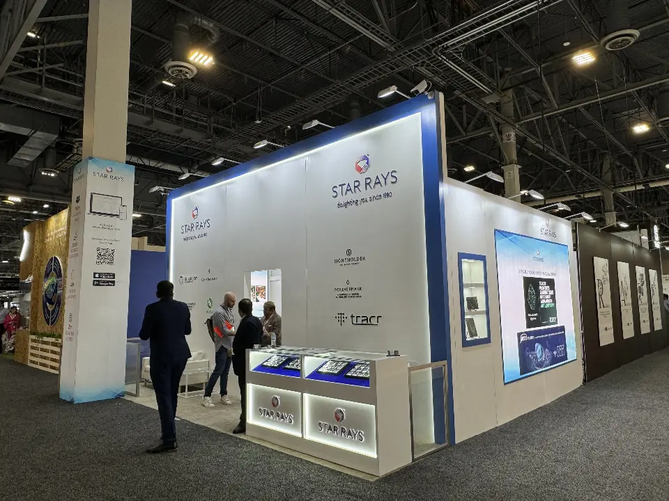 Corner view of the finished Star Rays booth with lit showcases and blue edge light