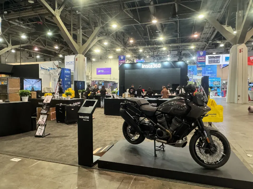 Motorbike display beside an Insta360 kiosk stand with black counters behind