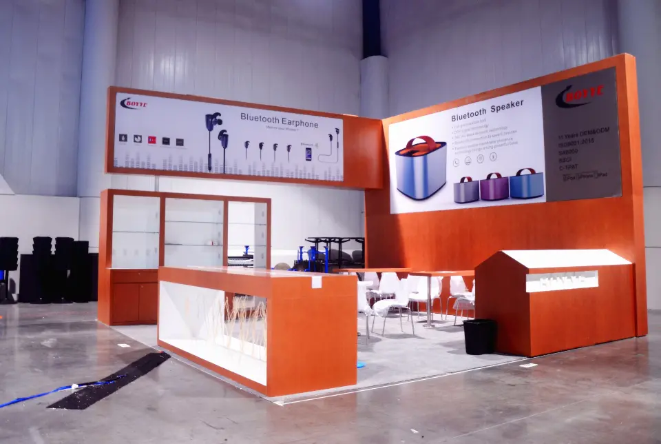 Wide view of the booth with lit counter, shelving wall and house-shaped stand
