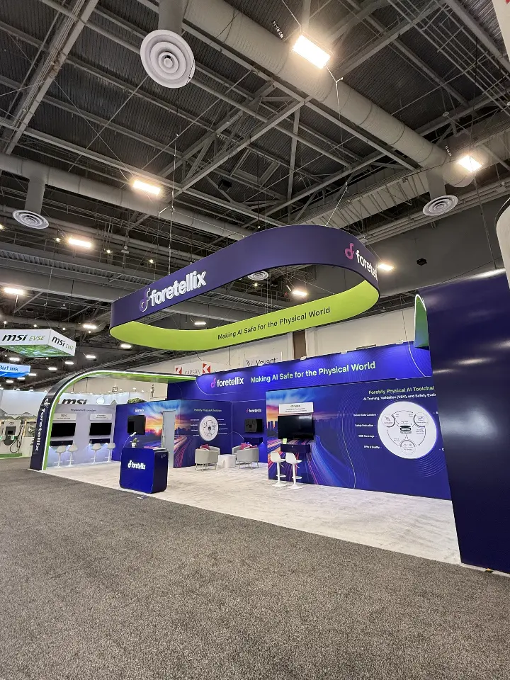 Diagonal view across the navy booth walls toward the lime-green overhead ring