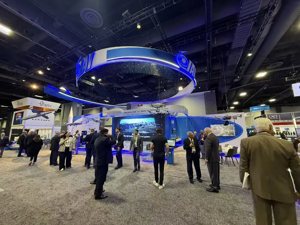 Visitors crowding the aisle in front of the IAI stand with its curved blue header ring