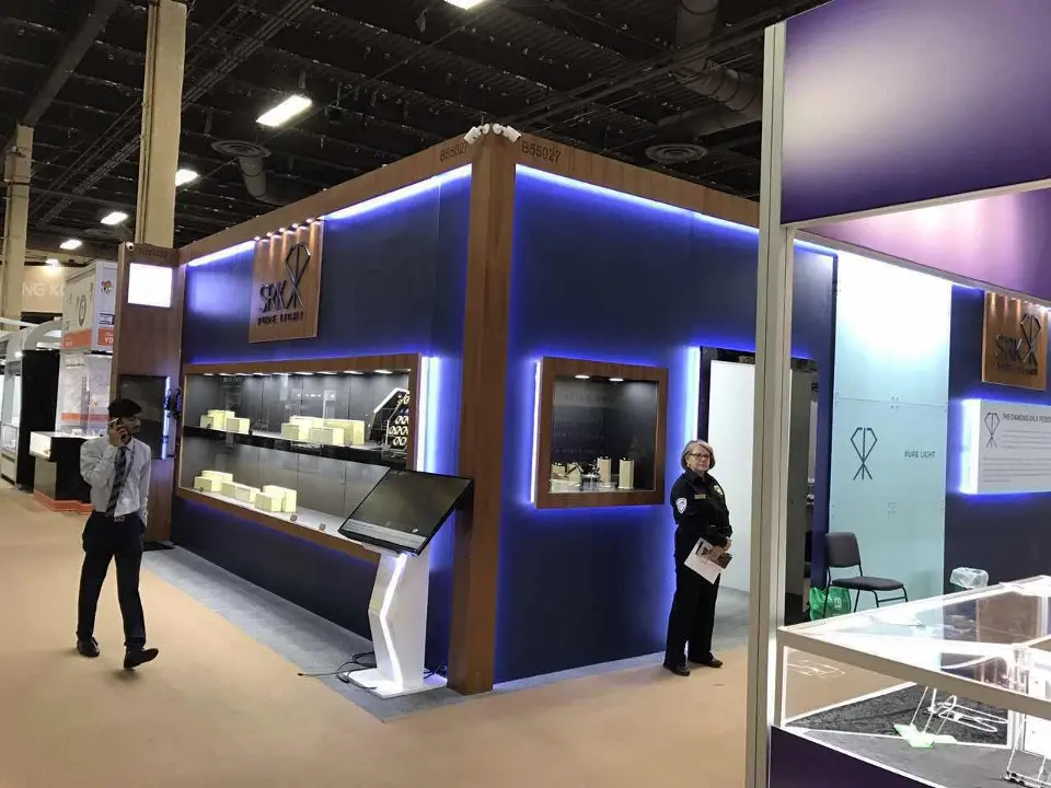 Navy facade with lit jewellery showcases and a staff member in the aisle