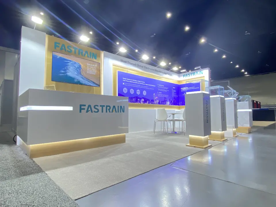 Finished FASTRAIN booth with lit counter, wall screen and a row of showcases