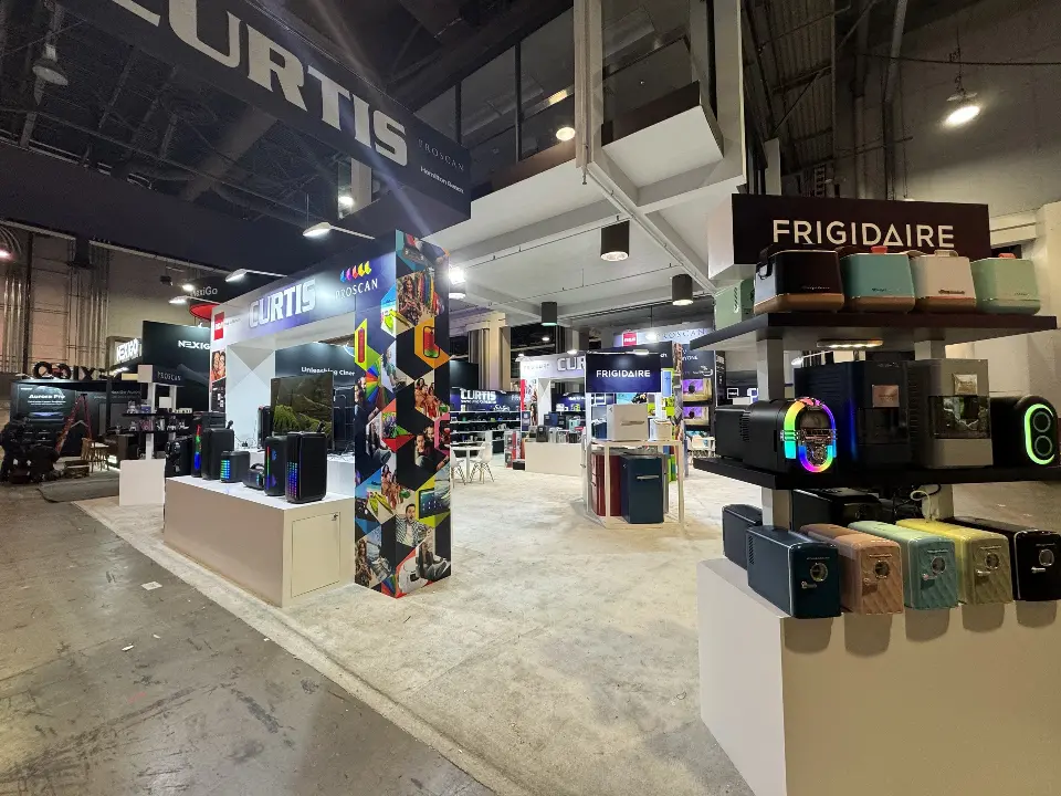 Colourful photo-collage column beside speakers on a white plinth