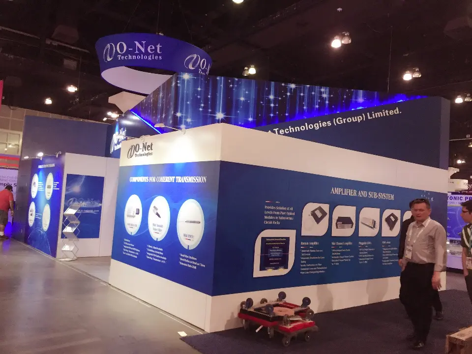 Outer wall of the O-Net booth with blue product graphics under a round hanging sign