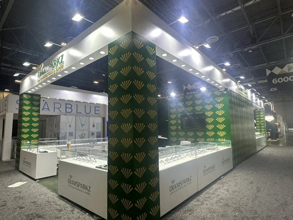 Empty booth corner with lit header and glass showcases before opening