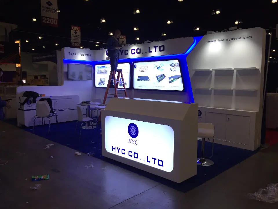 Backlit HYC CO.,LTD counter in front of the blue lit header at night